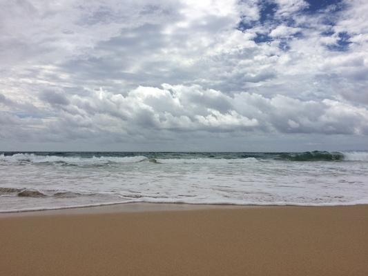 Waimea Beach with clouds and blue sky and waves breaking ... a wonderful beach that very few people go to. 