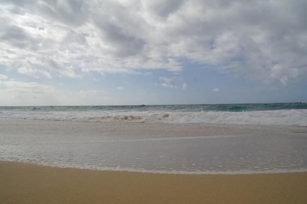 Clouds bring shade... the ocean stretching off into the distance... waves breaking on the beach...